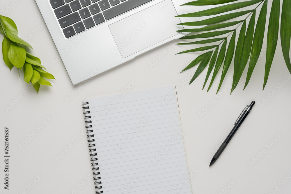 Workspace with blank notebook, laptop, office supplies and green leaves on white background. Workspace with blank notebook, laptop, office supplies and green leaves on white background.