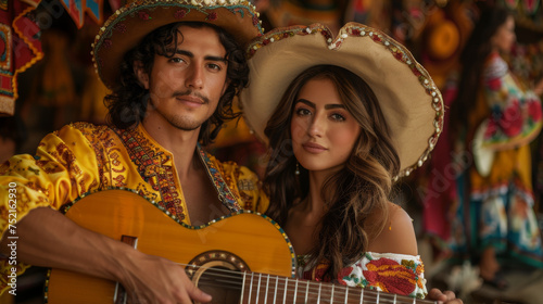 young man and woman dressed in mexican dress playing guitar © Vladislav