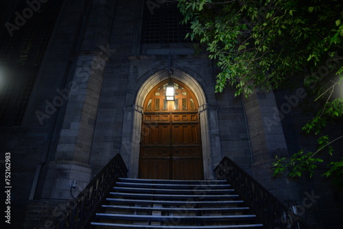 Wooden door by a staircase in the dark © Wirestock