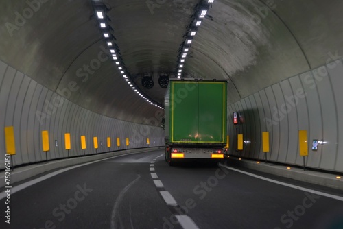 Green truck in a motorway tunnel on the Brenner Pass with new colored road boundaries and new LED lighting