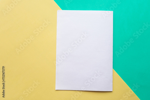White paper mockup blank on green and yellow geometric paper background, minimal concept