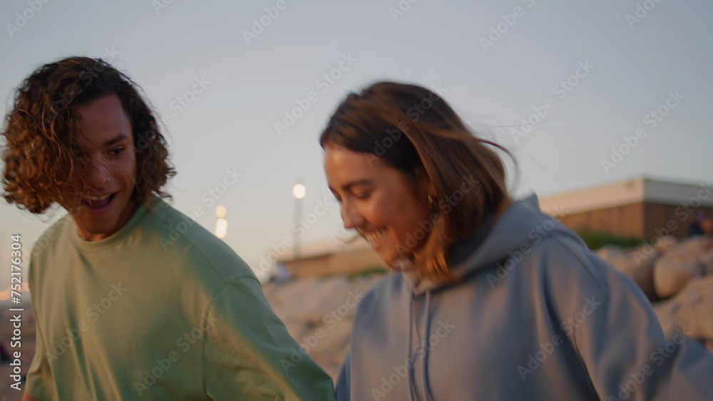 Carefree couple having fun at evening beach close up. Teenagers rejoicing ocean