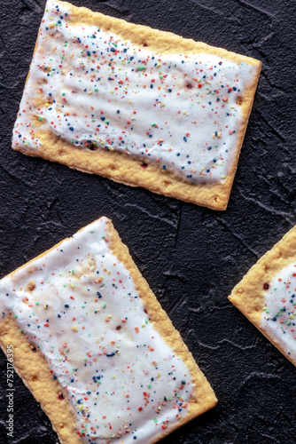 Pop tarts on black. Poptart toaster pastry with icing, shot from above, breakfast food