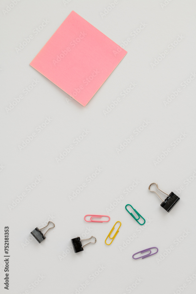 Office supplies top view with pink sticky notepad on white background. Office supplies top view with pink sticky notepad on white background.