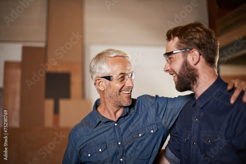 Man, hug and smile with wood, workshop and family business or apprenticeship. Mature father, son and embrace with artisan, carpentry and together for startup and mentor or learning with happiness