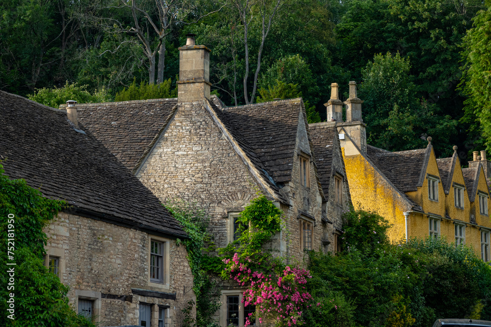 Wonderful old stone houses in Castle Combe overgrown with ivy and blooming roses