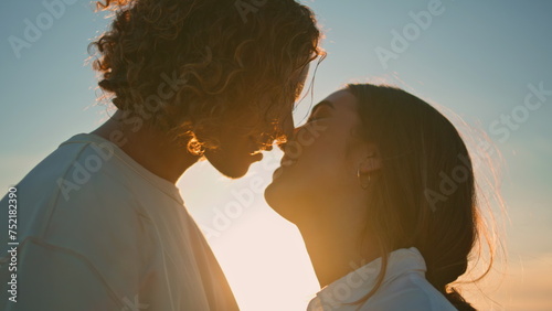 Obraz na płótnie Young pair kiss at sunset ocean coast close up