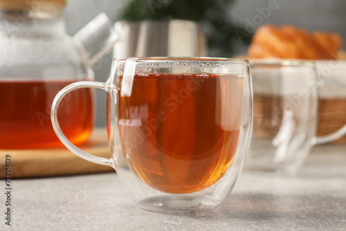 Aromatic tea in glass cup on light grey table