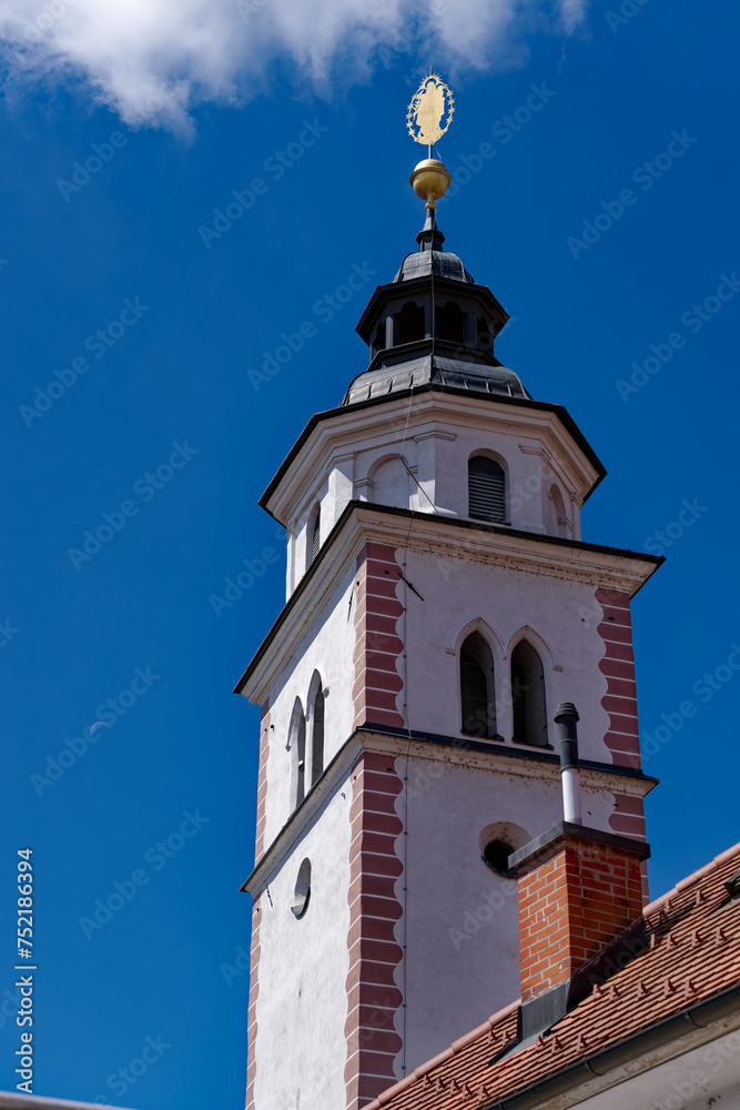 Old town of Slovenian City of Kranj with church tower of church named Cerkev Rožnovenske Matere Božje on a sunny summer day. Photo taken August 10th, 2023, Kranj, Slovenia.