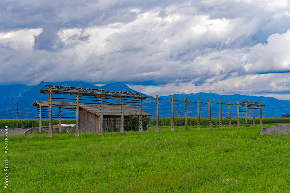 Wrecked hayrack with wooden barn at farmland at village of Zabnica on a blue cloudy summer evening. Photo taken August 10th, 2023, Zabnica, Kranj, Slovenia.