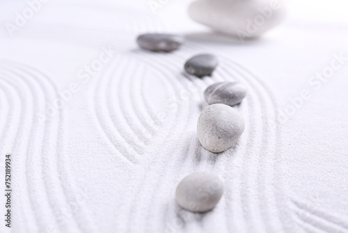 Zen garden stones on white sand with pattern, space for text