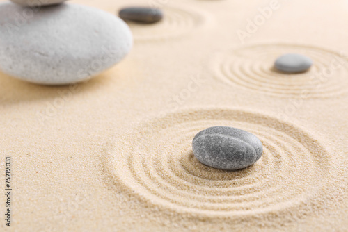 Zen garden stones on sand with pattern  closeup. Space for text