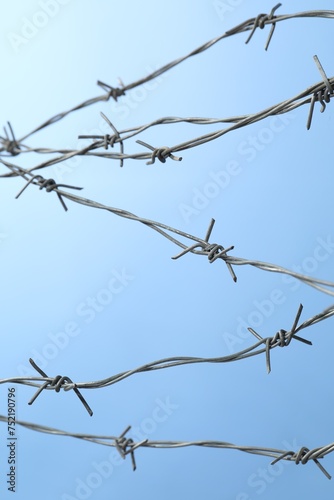 Metal barbed wire on light blue background