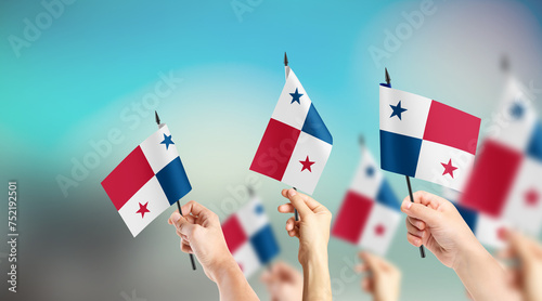 Fototapeta Naklejka Na Ścianę i Meble -  A group of people are holding small flags of Panama in their hands.
