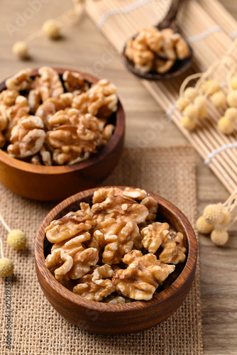 Organic raw walnuts in wooden bowl, Food ingredient