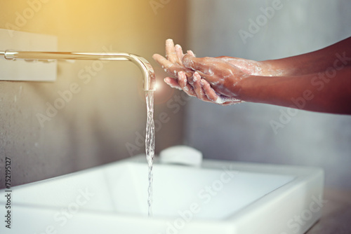 Hands, water and soap for cleaning with person in bathroom, hygiene and wellness for protection from germs. Bacteria, virus and disinfection at sink with foam, skincare and cosmetics in routine photo