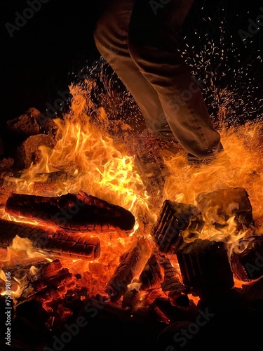 Person standing on a burning wood with flames