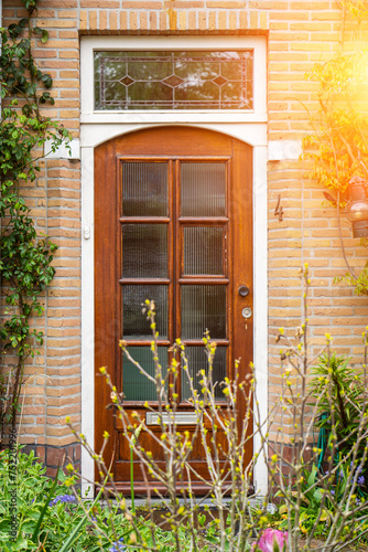 Facade of typical Dutch door house with brick walls  steps  front door windows. Doors on the street  Netherlands
