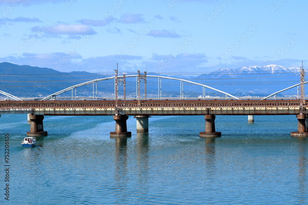 雪の積もった蓬莱山と瀬田川を渡る橋