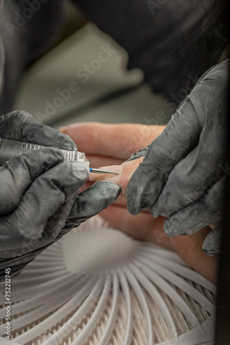 Manicurist fixing nails of a client © Wirestock