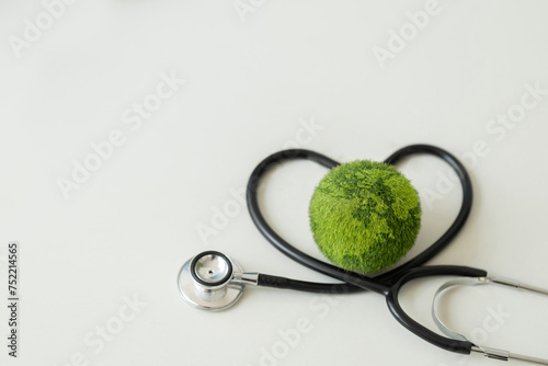 Environment Earth Day Concept.Green Earth with a medical doctor's stethoscope.Saving the environment and environmentally sustainable. saving the clean planet.Global healthcare and Green Earth Day. ESG