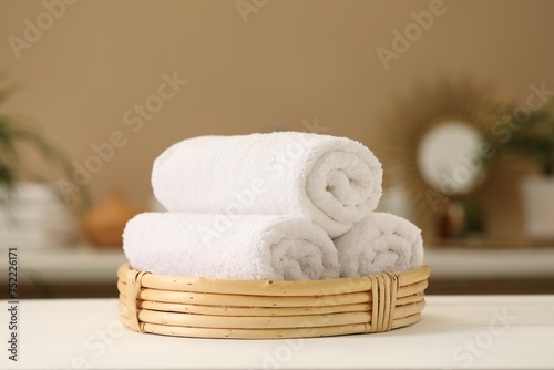 Spa composition. Rolled towels on white table indoors