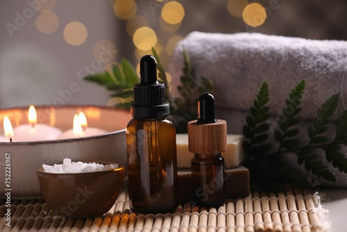 Beautiful composition with different spa products on table against blurred lights, closeup
