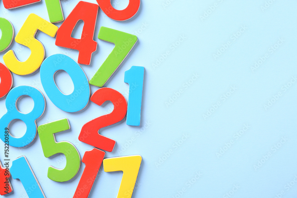 Colorful numbers on light blue background, flat lay. Space for text Colorful numbers on light blue background, flat lay. Space for text