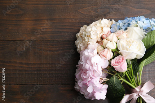 Bouquet of beautiful hydrangea and rose flowers on wooden background  top view. Space for text