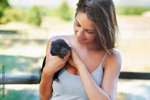 Woman, pig and animal in outdoor or farmy for pet, volunteer and bonding for play and care. Young person and smile with piglet in hand for adorable, love and cute for stroke on fur for affection photo