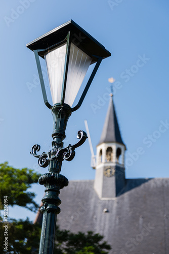 Close up of a classic standing street light in the village Oudenhoorn in the Netherlands. The reformed protestant church is in the background. photo