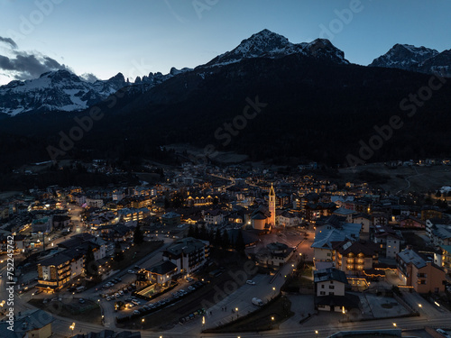 Aerial drone view of Andalo town at night with mountains background in winter. Snow covered Italian Dolomites at winter.Ski resort Paganella Andalo, Trentino-Alto Adige, ItalyItalian Dolomites