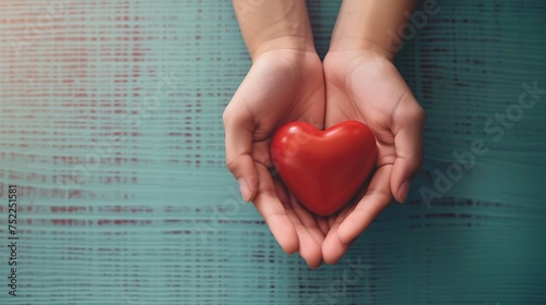 Hands holding heart, hands supporting red heart, world heart day, world health day. Copy space.