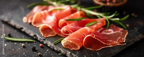 Spanish jamon ham sliced on black modern slate top view. © Filip