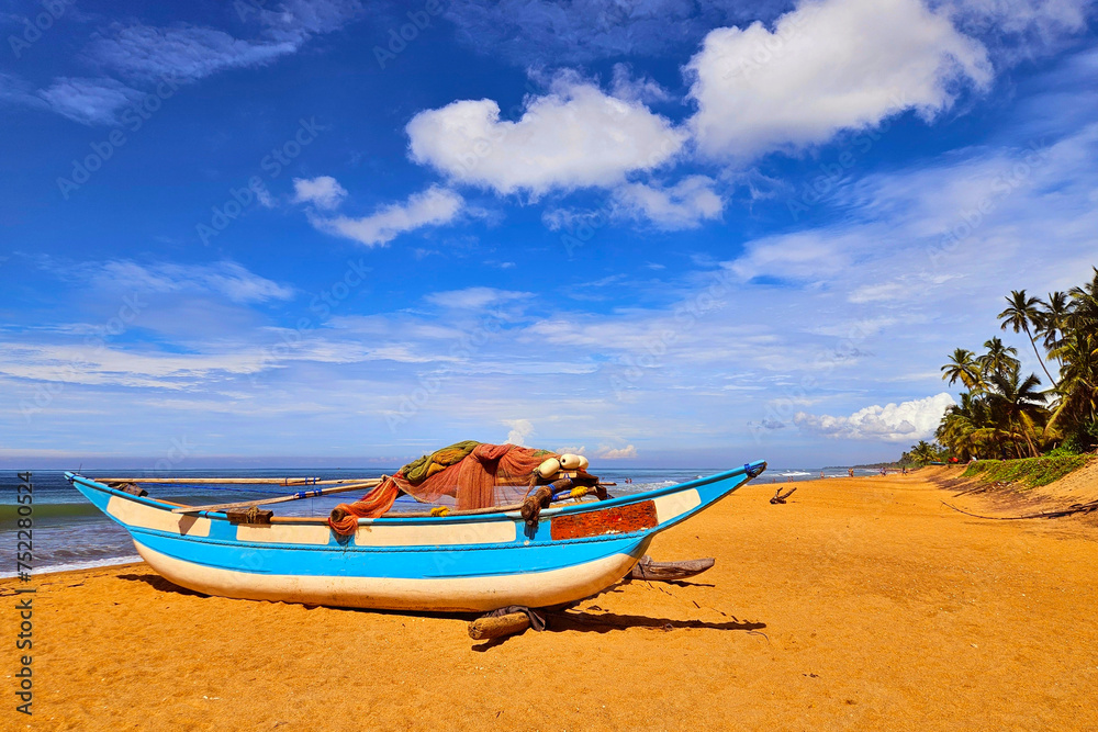Fishing boat on sand of Waskaduwa beach, Sri Lanka.