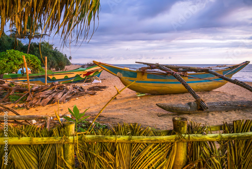 Old fishing boats on sand of Waskaduwa beach, Sri Lanka.