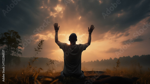 Man worship or pray with sunset background. Copy space of man rise hand up on top of mountain and sunset sky abstract background. Freedom and travel adventure concept. Tone filter effect color style.