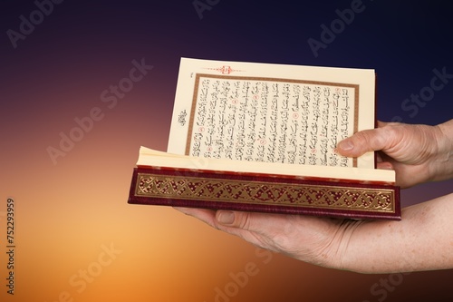 a man holding big holy Quran book in hands