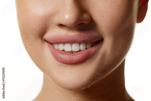 Close-up of woman s lower face  highlighting smooth skin  plump lips and white teeth. Model posing against white background. Concept of natural beauty  cosmetology  cosmetics  skin care  dental care