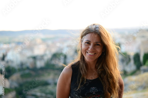 Portrait of a smiling Latin woman with hair illuminated by evening light