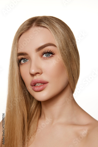 Portrait of elegant, attractive young woman with straight blonde air, smooth, clean skin and plump lips isolated on white studio background. Concept of natural beauty, cosmetology, cosmetics, skincare