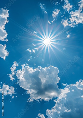 View of the sun in the blue sky with clouds. © Simona