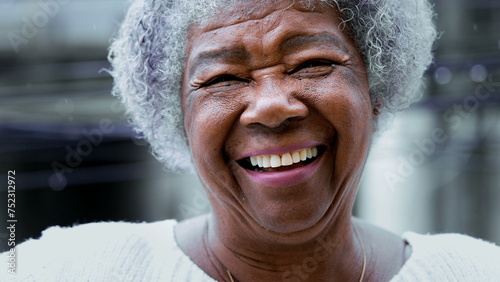One joyful black elderly woman with gray hair, wrinkles, and happy friendly smile. Charismatic South American senior person of African descent portrait face close-up photo