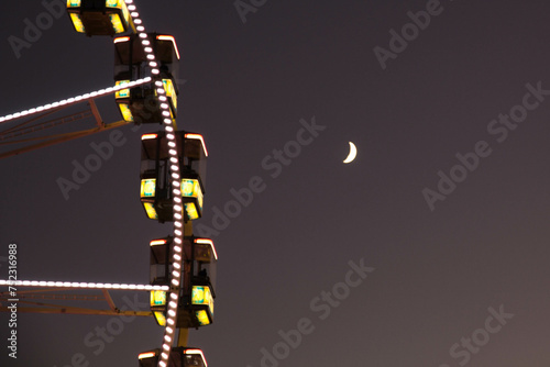 Evening at the city with fun fair wheel and moon in the sky at Ghent Belgium © Horacio
