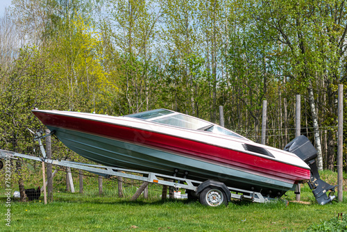 A motorboat on a trailer on a green meadow