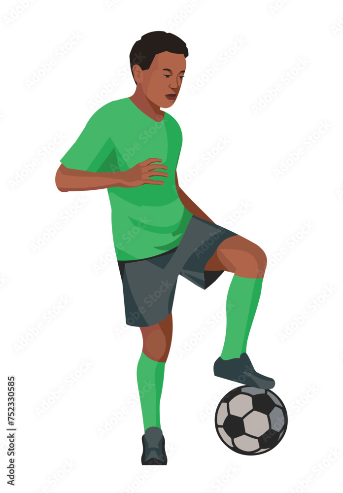 Southern African boy in green sports uniform standing in a half-turn placing his foot on the ball on junior football training or championship