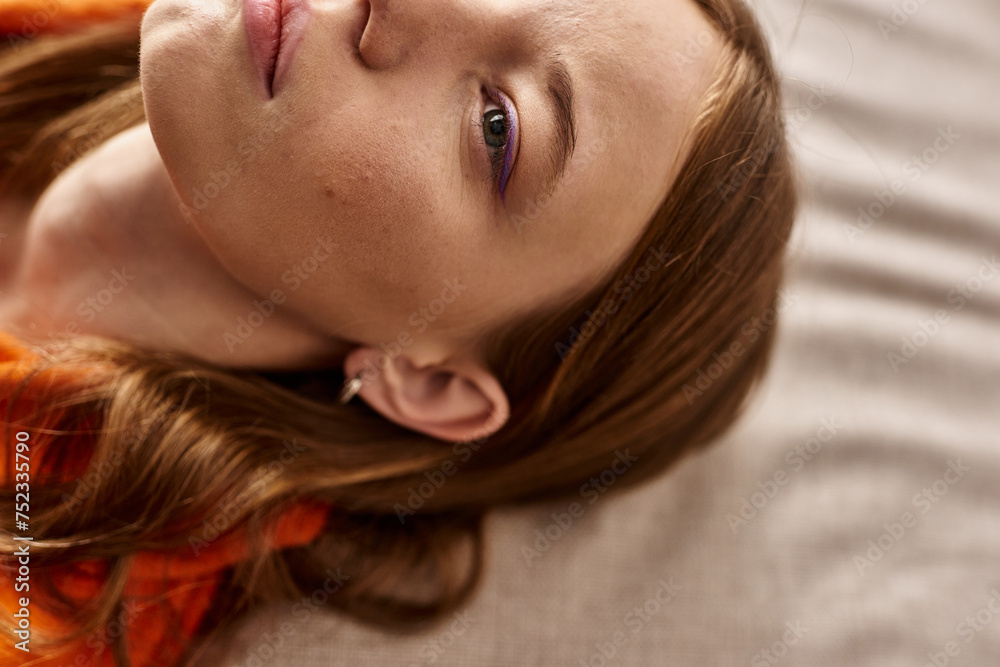 top view of teenage girl with skin concern lying down on couch, zoomer lost in thought top view of teenage girl with skin concern lying down on couch, zoomer lost in thought
