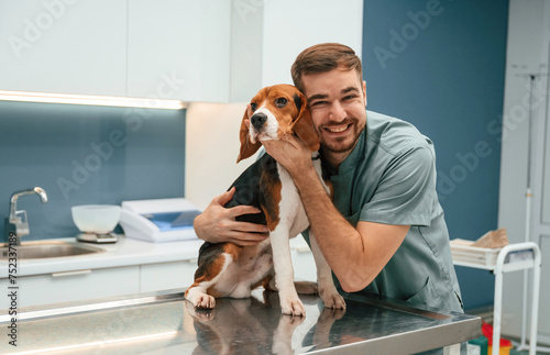 Playful mood, having fun. Dog in veterinarian clinic with male doctor