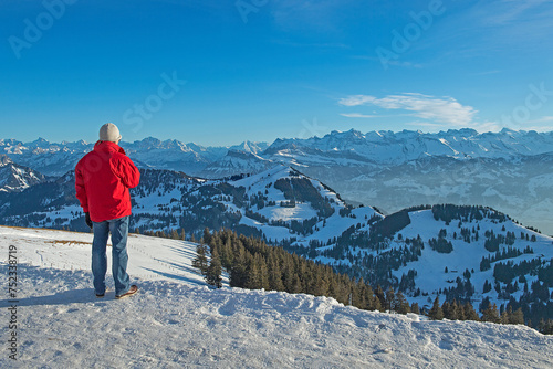 Tourist geniesst die Aussicht von Rigi-Kulm auf die verschneite Gebirgslandschaft, Schweiz © tauav
