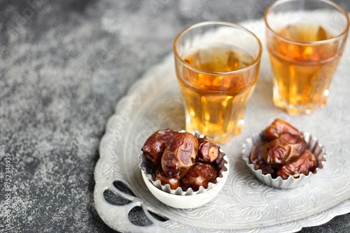 Kurma  or Dried Dates and hot tea on silver tray.  photo